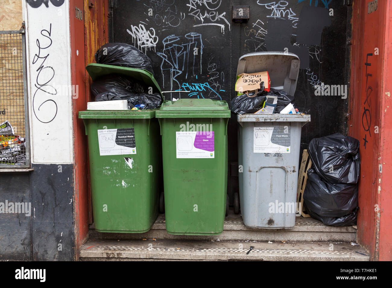 Full and overflowing rubbish bins from business premises waiting to be