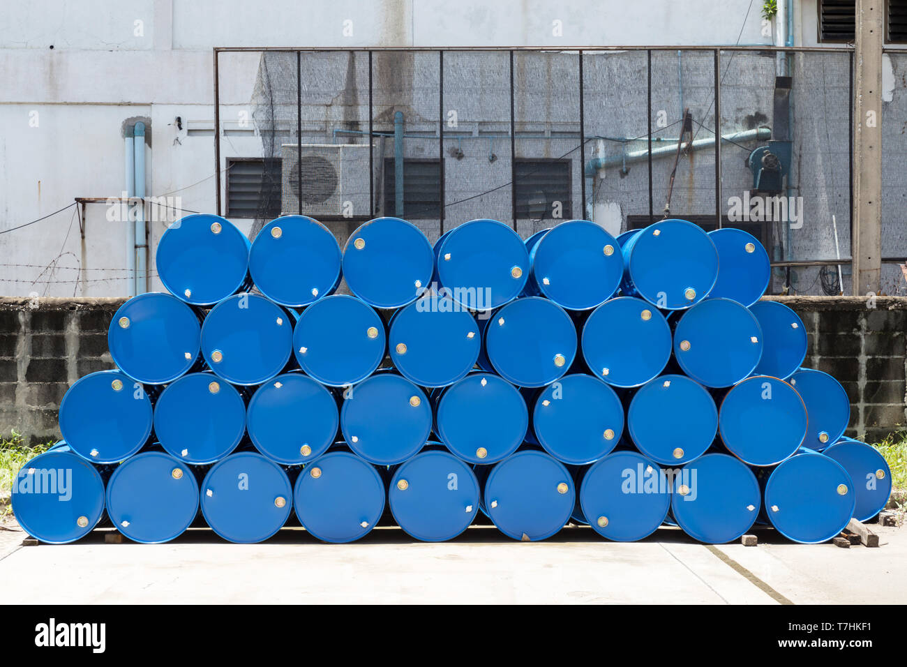 empty recycle blue steel chemical tanks for oil fuel barrels stacked in a row at the factory storage. background and texture Stock Photo