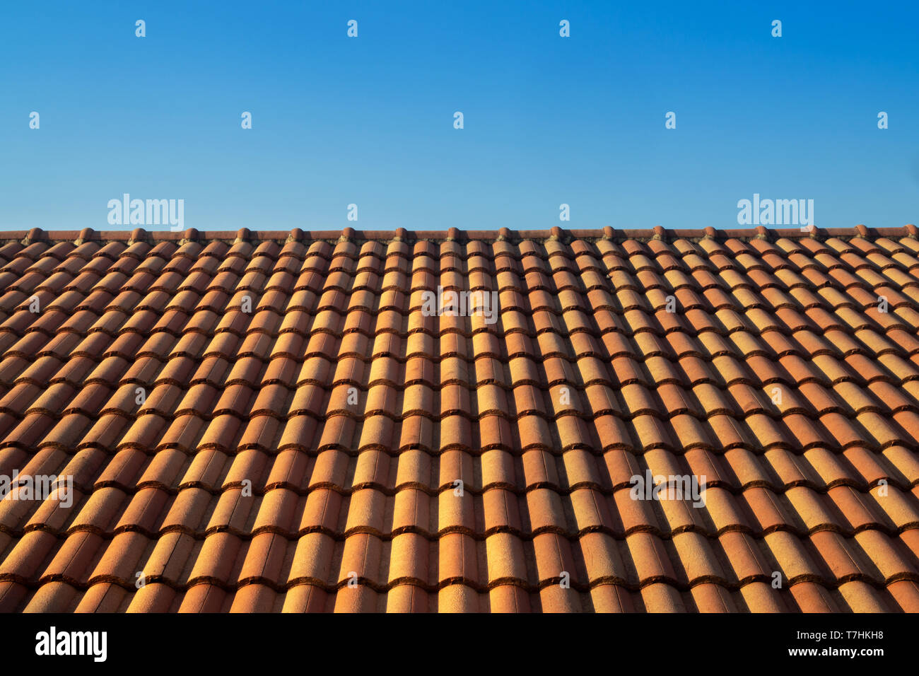 orange roof tile house against blue sky and warm sunlight at the summer time. housing and real estate concept. Stock Photo