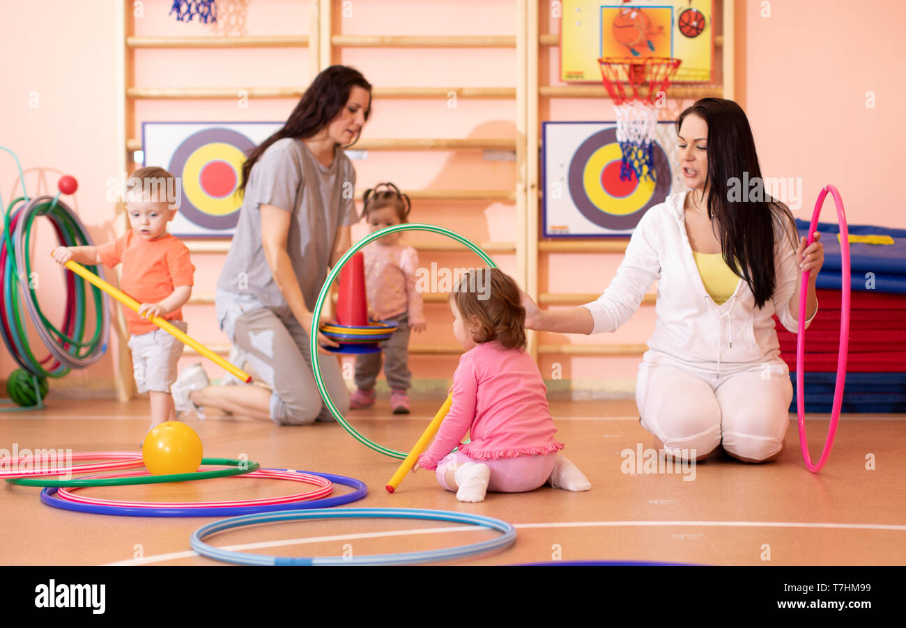 Kids toddlers play with adults in kindergarten gym Stock Photo Alamy