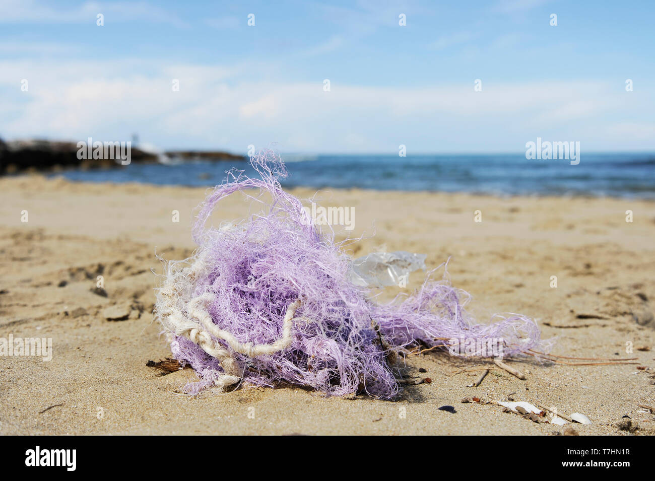 Fishing nylon net on the sand. Garbage on the beach. Dirty sea