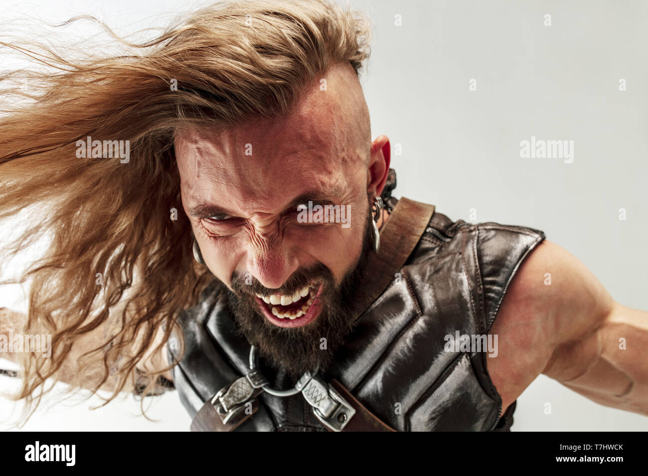 God Of Thunder Blonde Long Hair And Muscular Male Model In Leather Viking S Costume With The Big Hammer Cosplaying Thor Isolated On White Studio Background Fantasy Warrior Antique Battle Concept Stock Photo