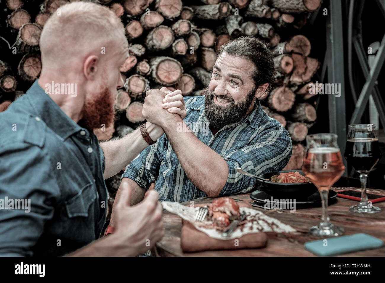 Two concentrated mature men competing in arm-wrestling. Stock Photo