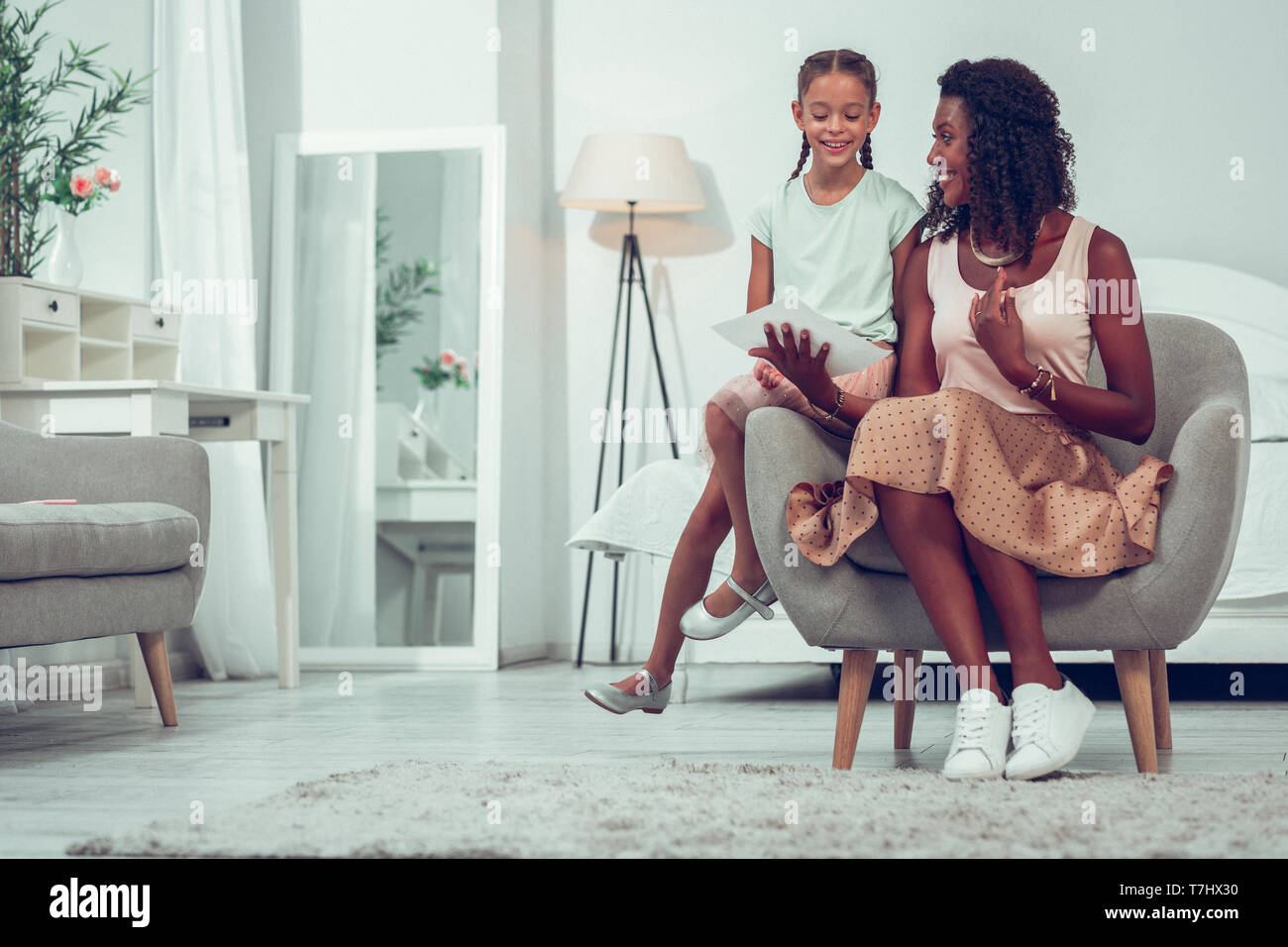 Beautiful mom discussing drawings with cute little pretty cheerful child Stock Photo