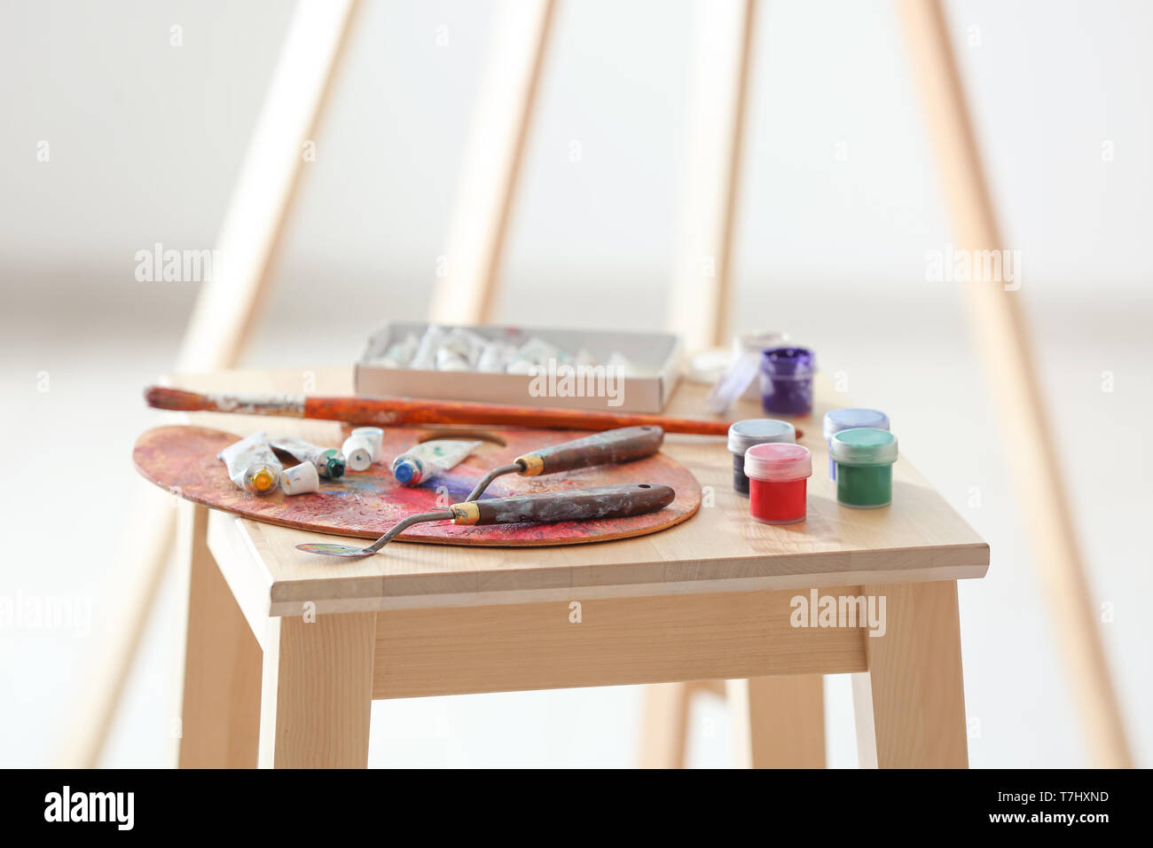 Tools and paints of professional artist on wooden chair Stock Photo