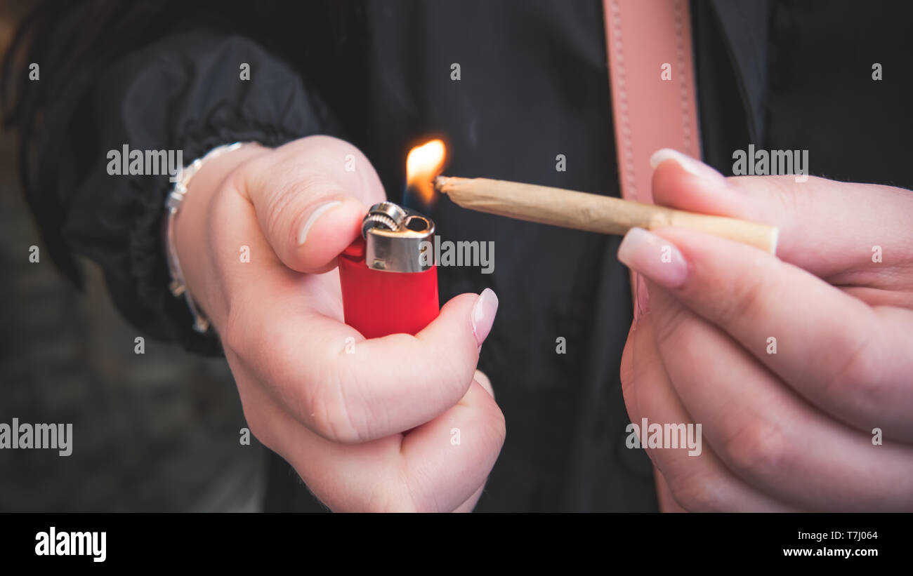 Marijuana joint in the female hand closeup. Woman smoking medical