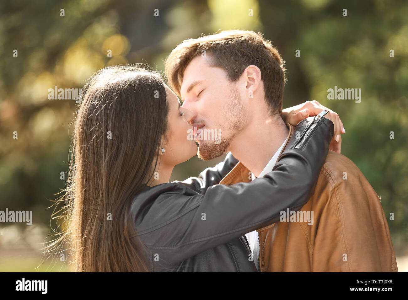 Young lovely couple kissing outdoors Stock Photo