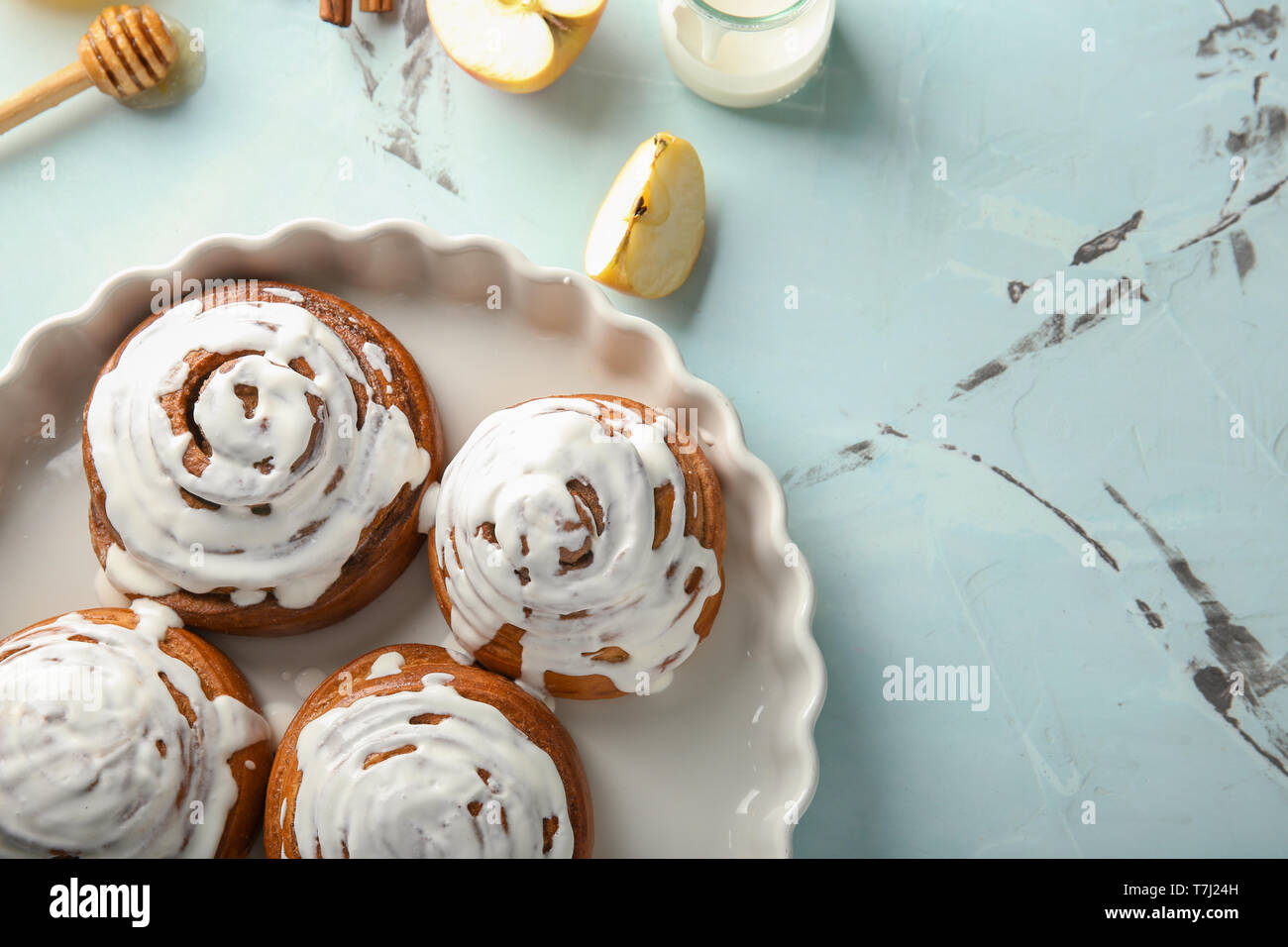 Dish with glazed cinnamon buns on table Stock Photo