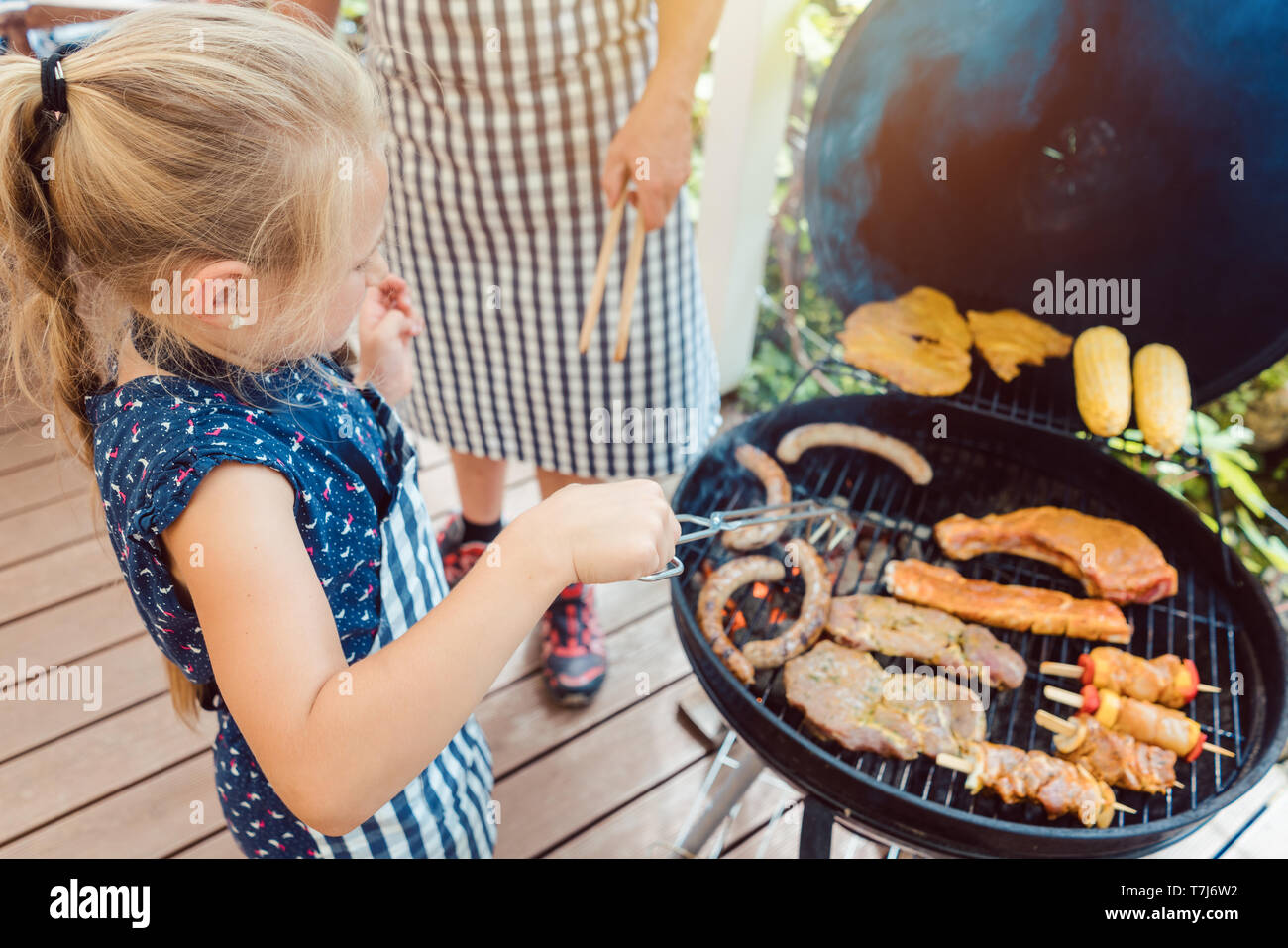Dad and kid doing the barbeque at the grill Stock Photo