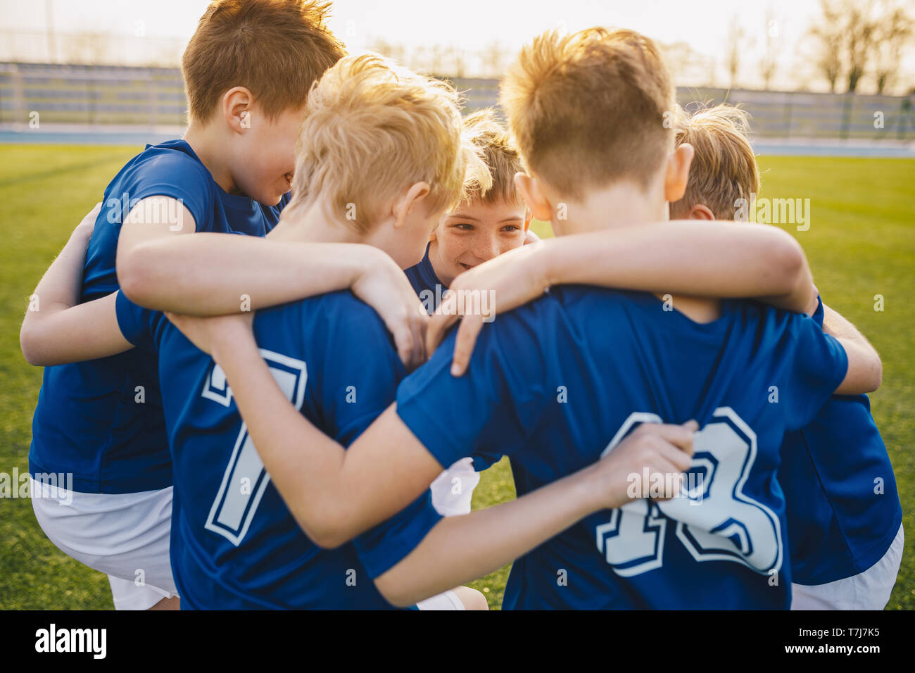 Happy kids in school sports team. Boys gathering and having fun on sports field. Cheerful children boys players of school soccer team. Happy boys in j Stock Photo