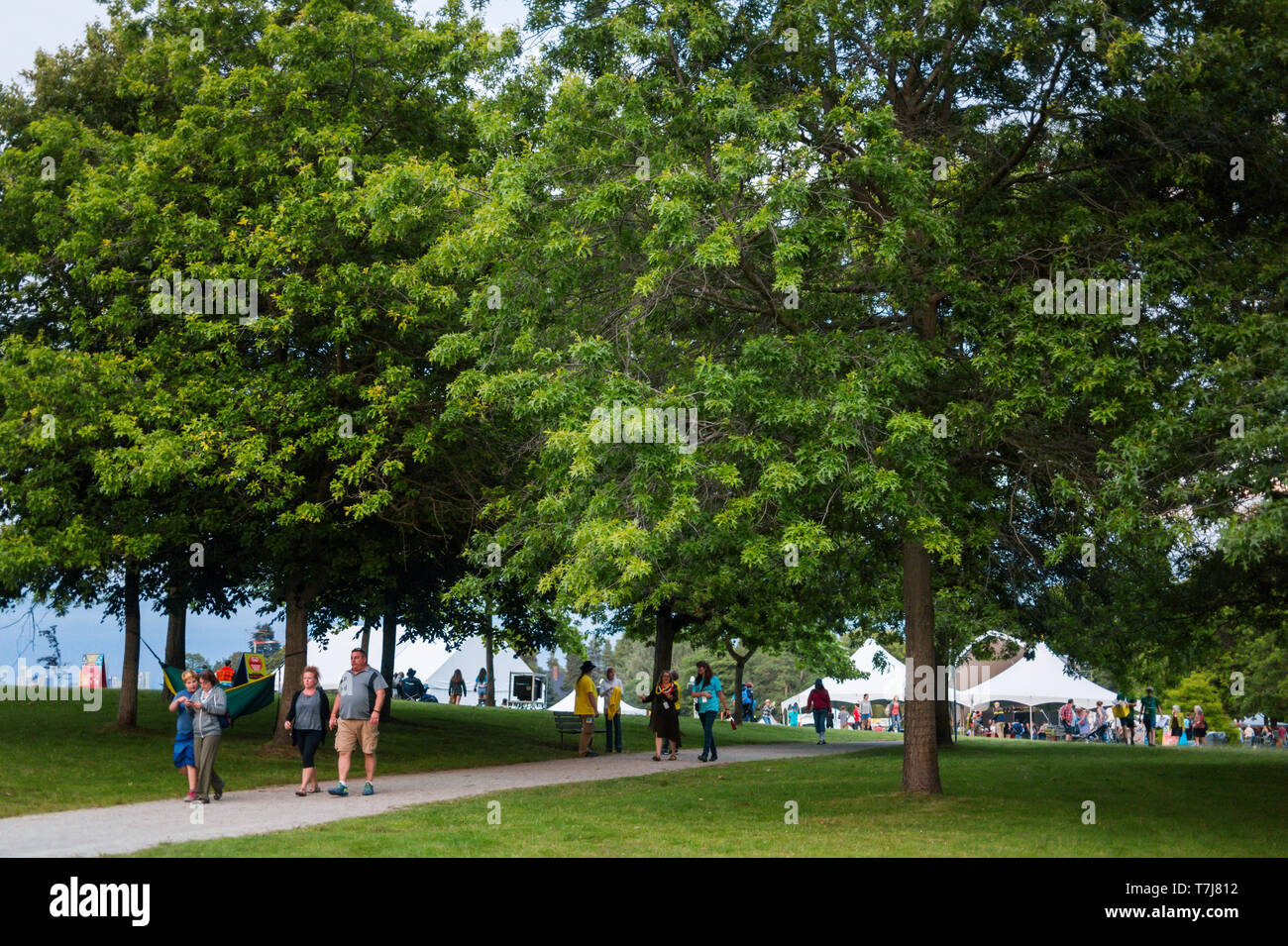 Attendees walk through Jericho Beach Park during the Vancouver Folk Festival in British Columbia, Canada Stock Photo