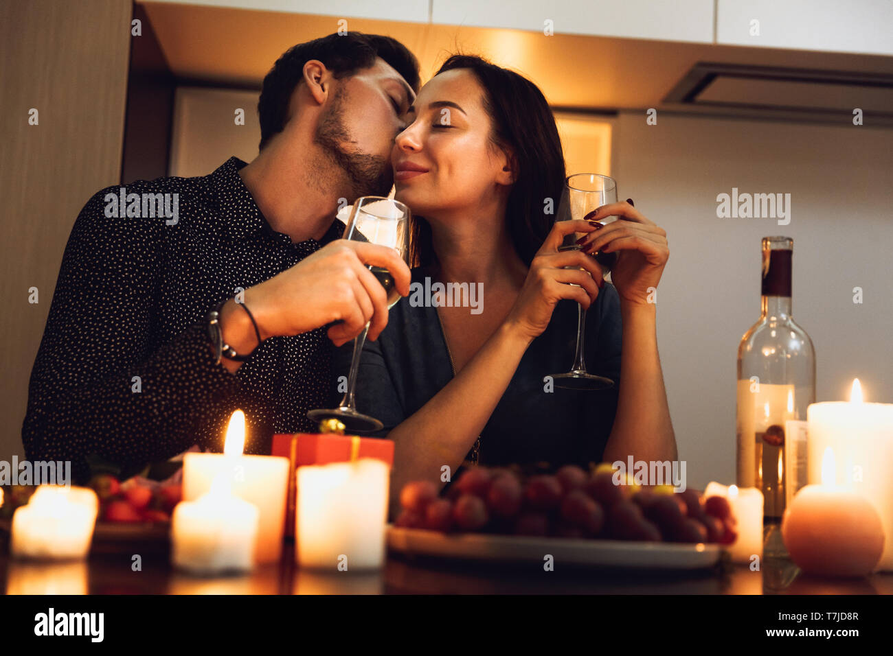 Beautiful passionate couple having a romantic candlelight dinner at