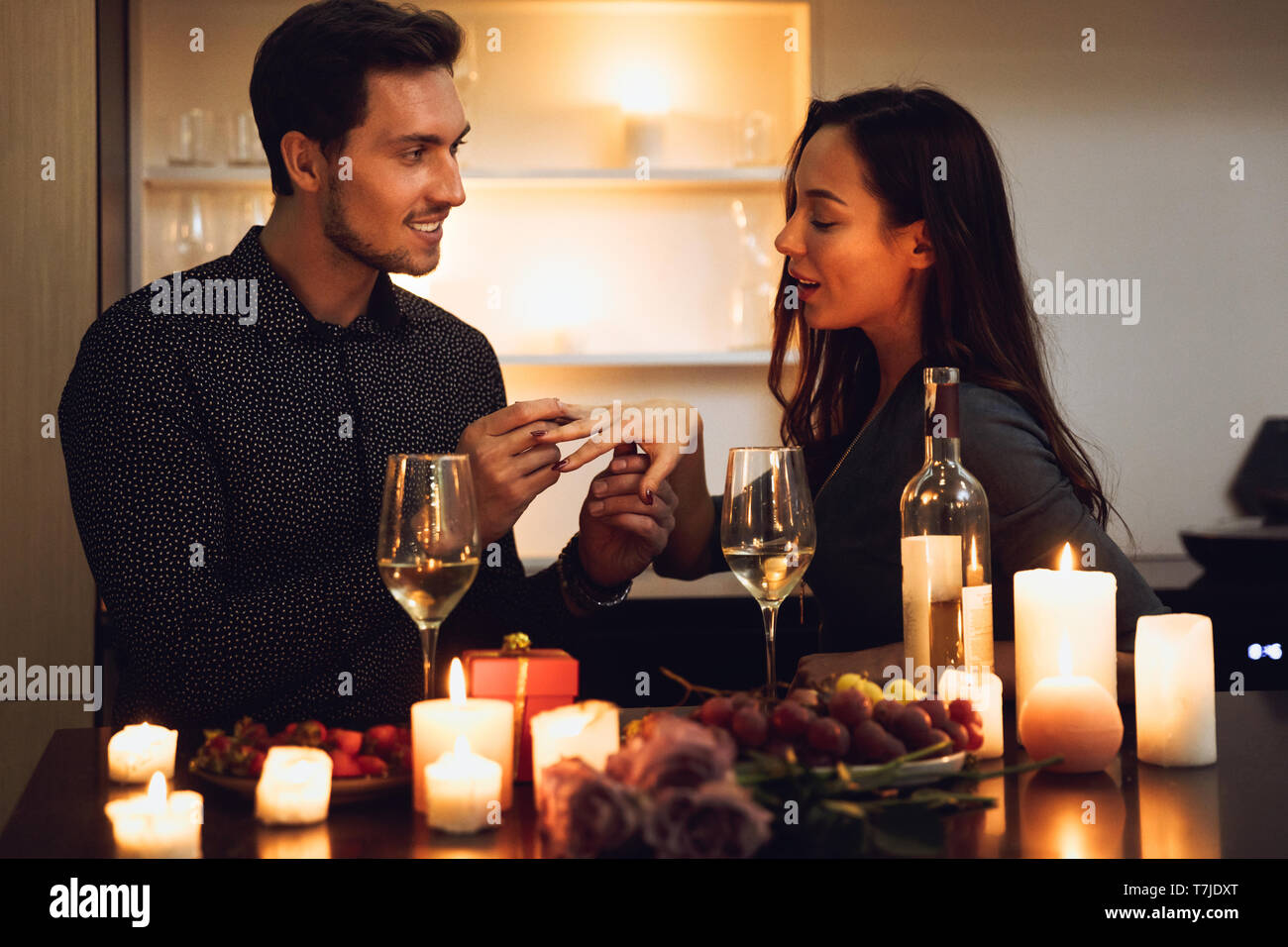 Beautiful passionate couple having a romantic candlelight dinner at home, man making a proposal