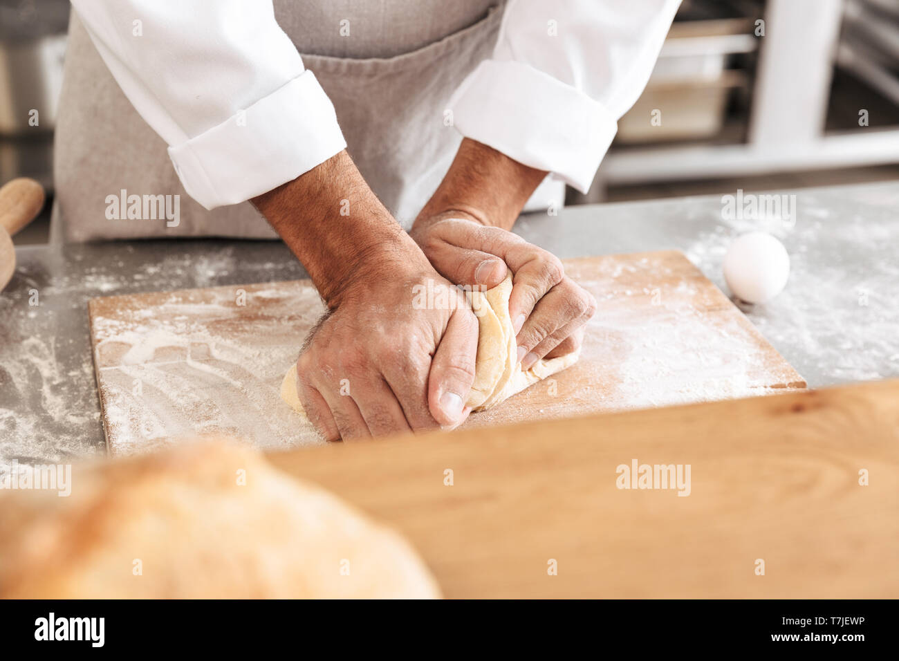 Closeup portrait of male hands mixing dough for pastry on table at ...