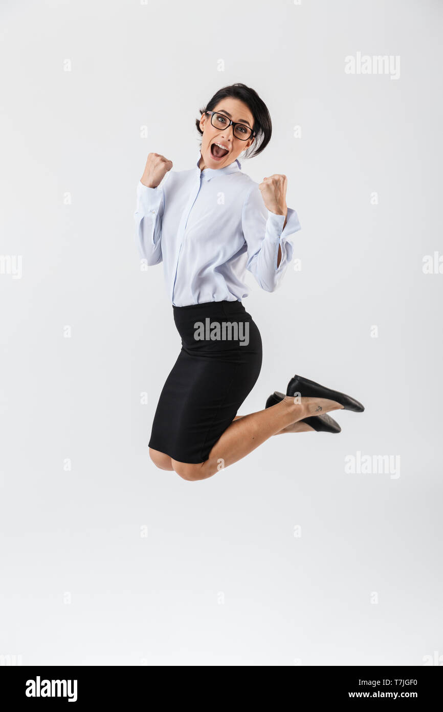 Full length portrait of a pretty businesswoman jumping isolated over ...