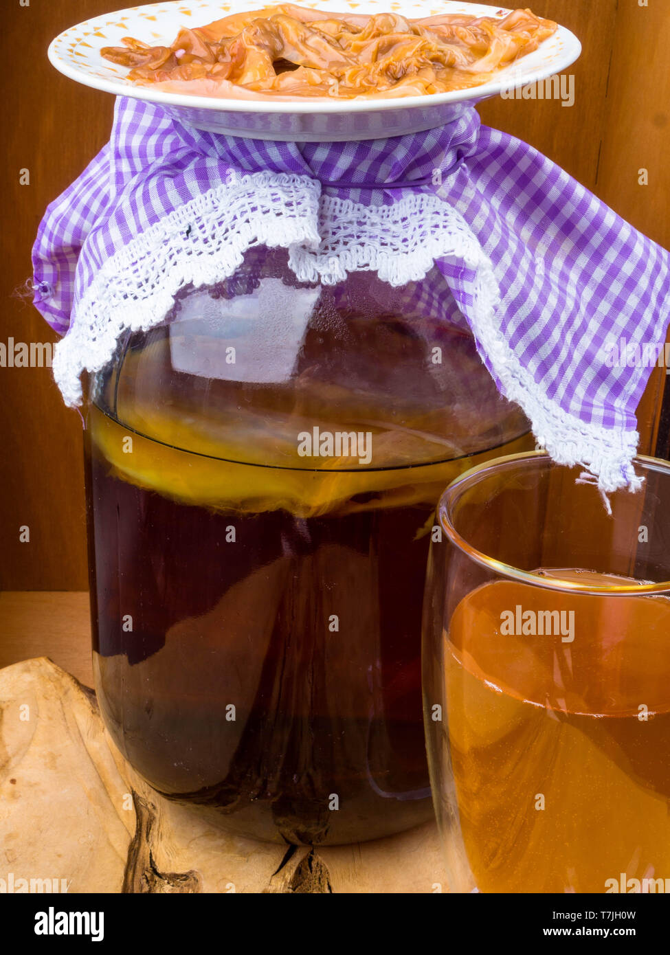 Kombucha superfood pro biotic beverage in glass, bottle background