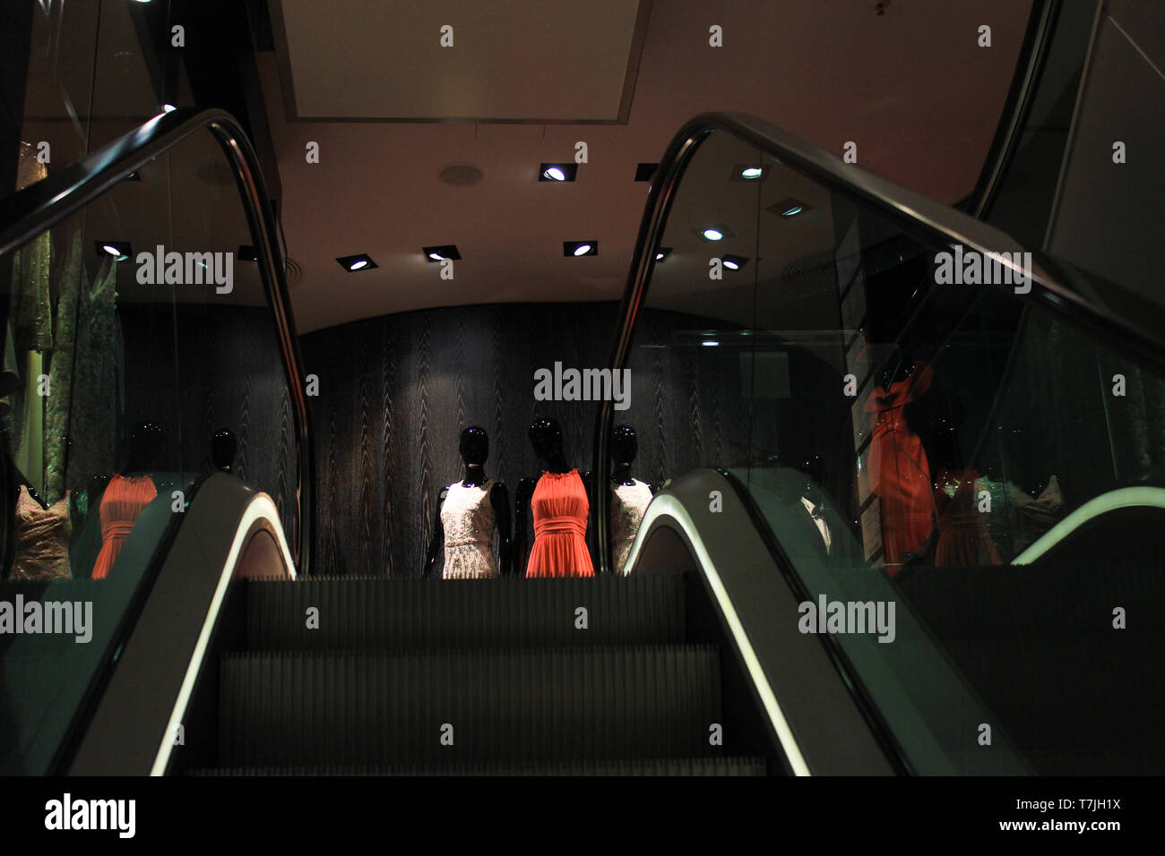 Luxury shopping:, symbold picture, display dummys, expensive fashion behind moving staircase. Stock Photo