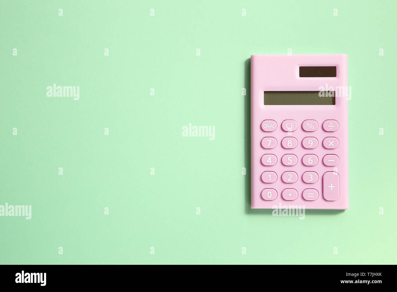 Pink digital calculator on green background Stock Photo