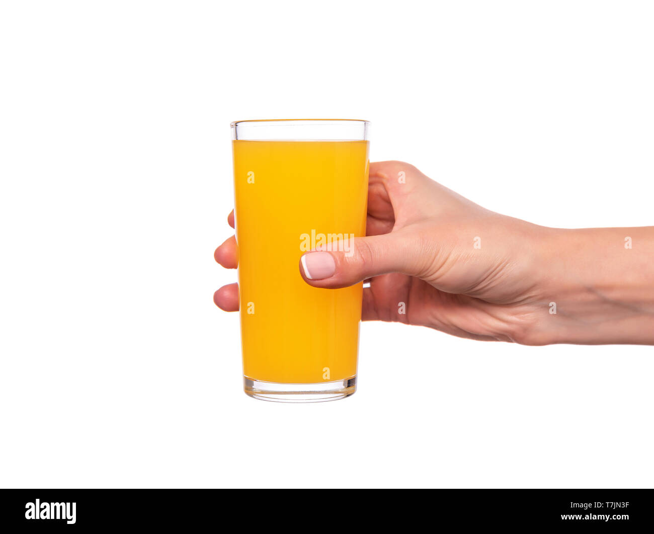 Female hand holding a glass with orange or citrus juice on white background. Stock Photo