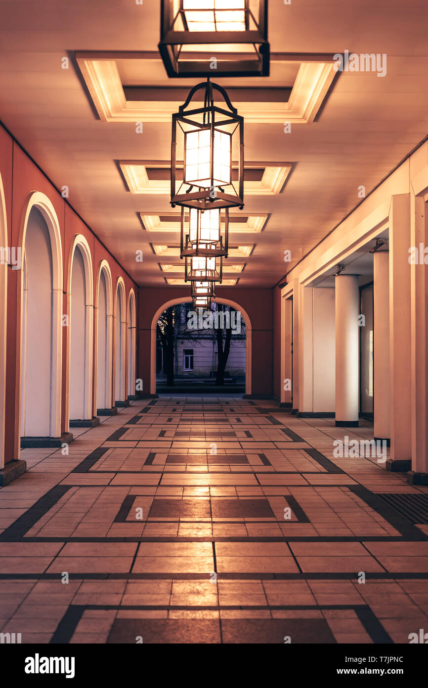 View of the gallery in twilight with arches lighted by antique lanterns in city center of Moscow. Stock Photo