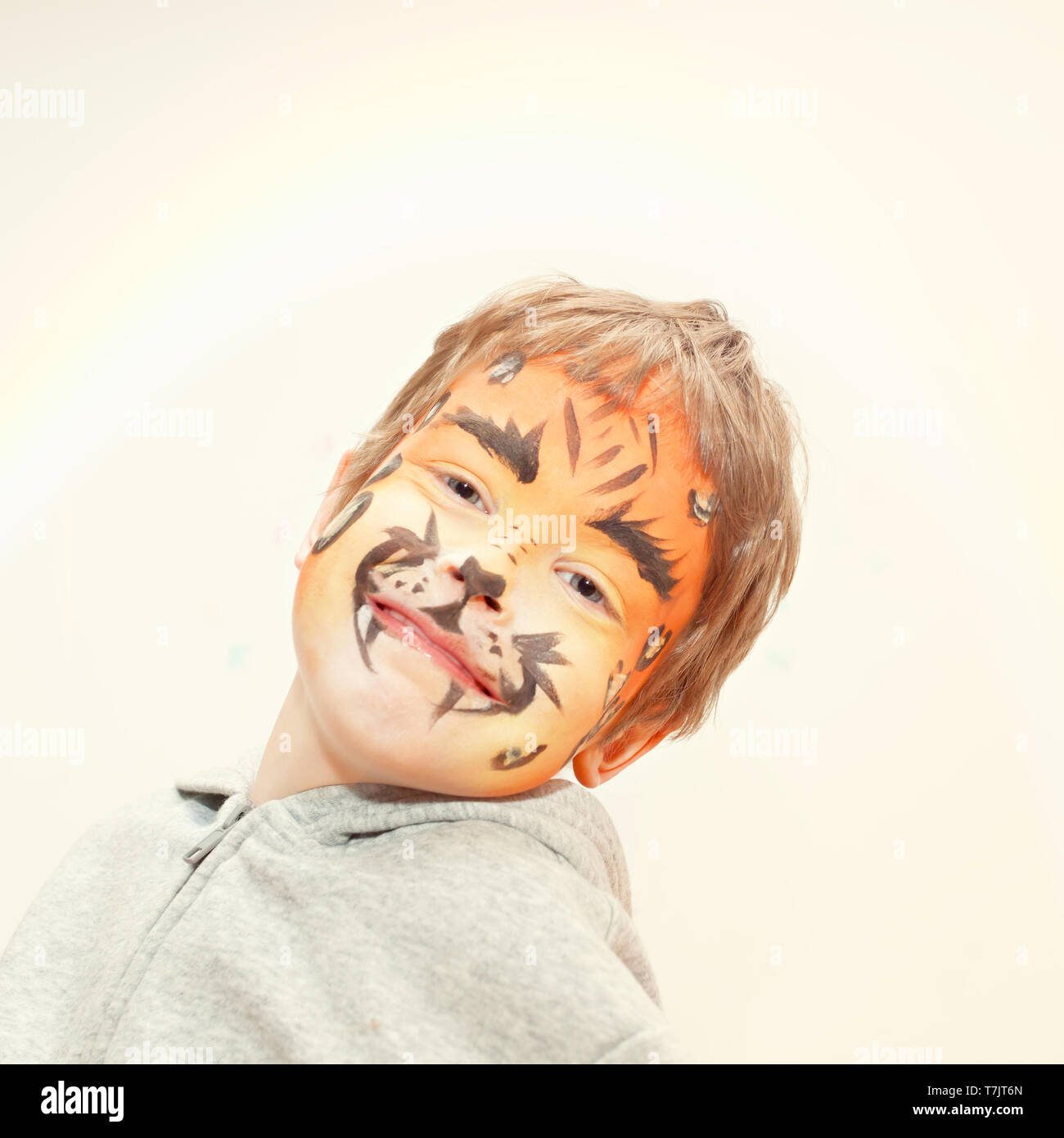 Happy five year old boy with leopard face paint on a birthday party Stock Photo