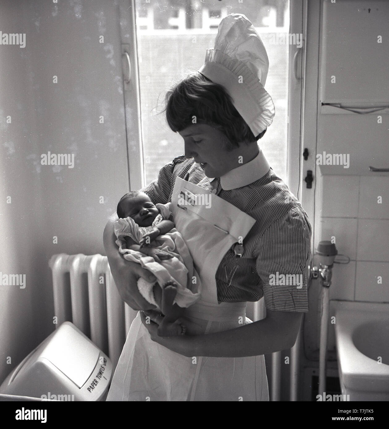 1960s, historical, a nurse standing holding a newly  born baby, England, UK. Stock Photo
