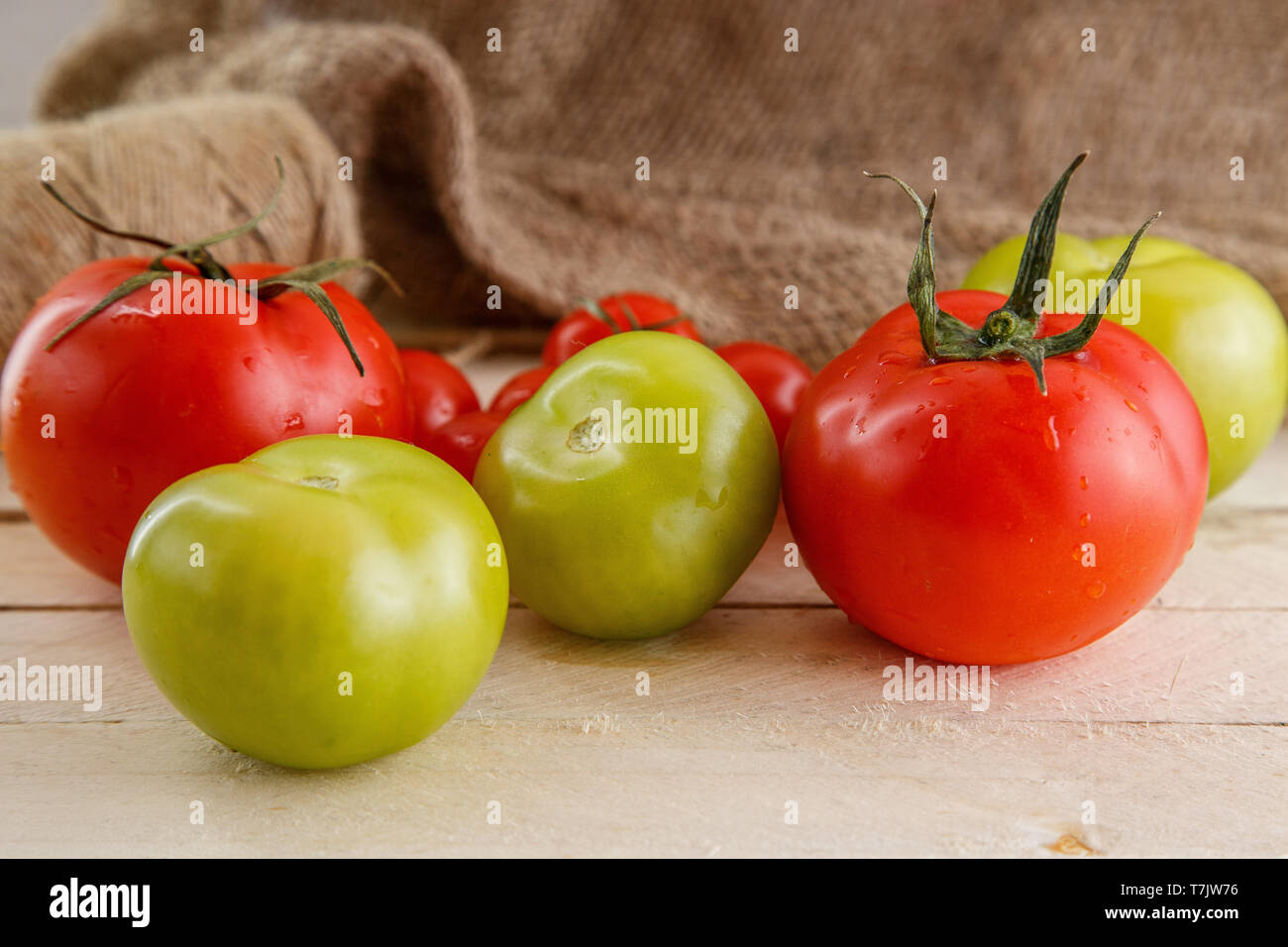 different types of tomatoes on a light wooden background Stock Photo ...