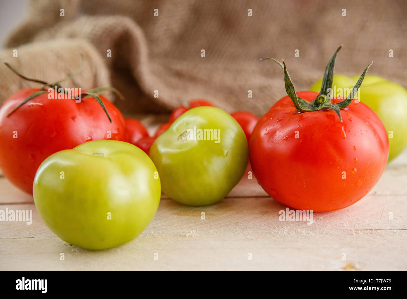 different types of tomatoes on a light wooden background Stock Photo ...