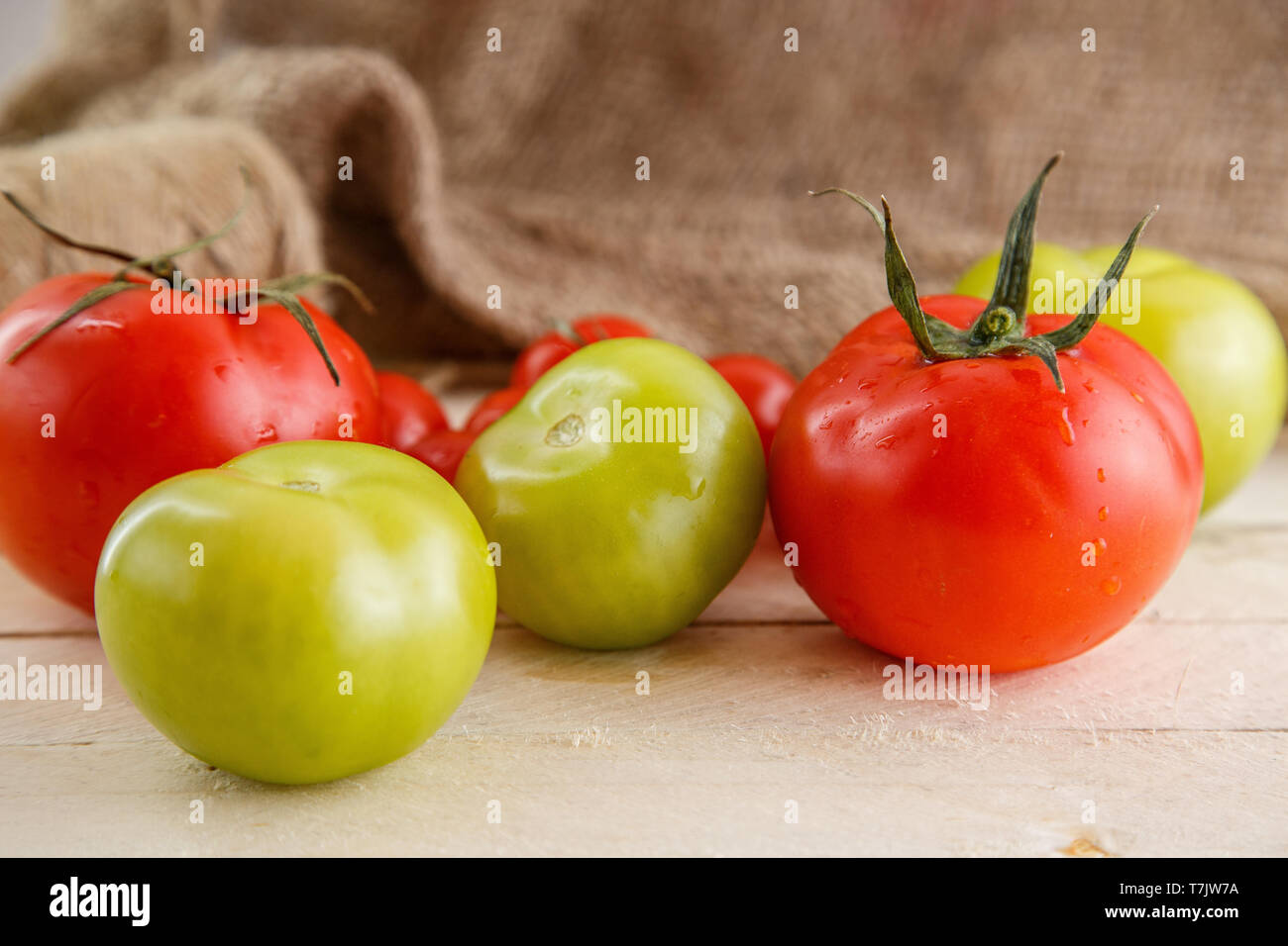 different types of tomatoes on a light wooden background Stock Photo ...