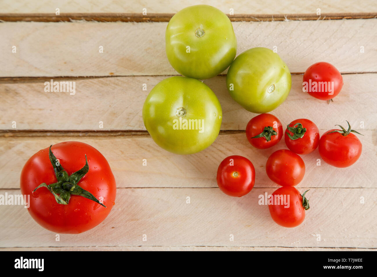 different types of tomatoes on a light wooden background Stock Photo ...