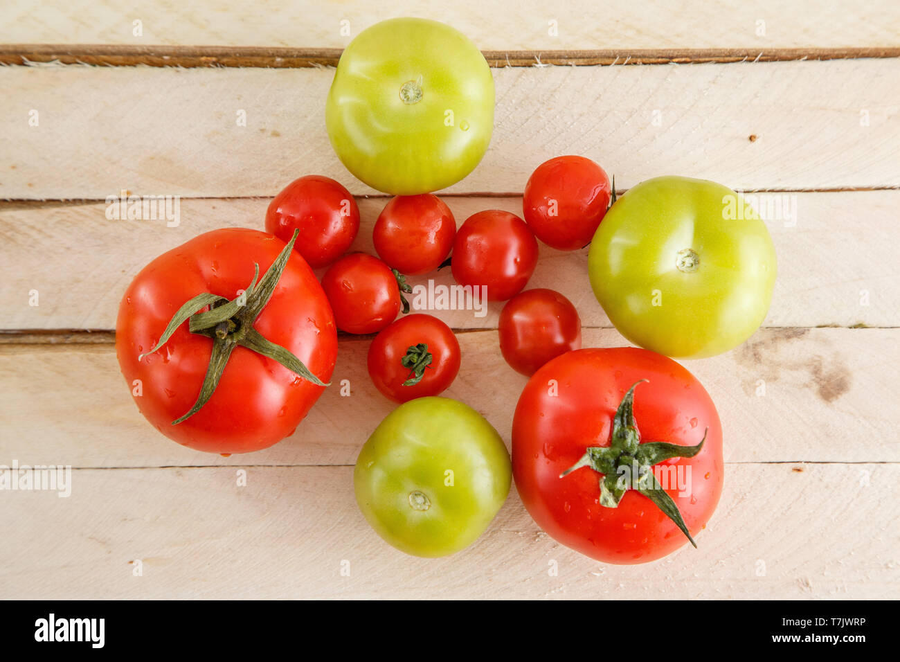 different types of tomatoes on a light wooden background Stock Photo ...