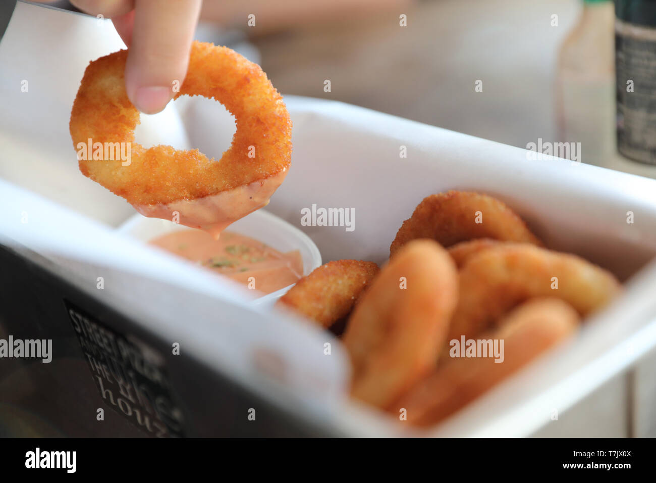 Onion rings with sauce on wooden table Stock Photo