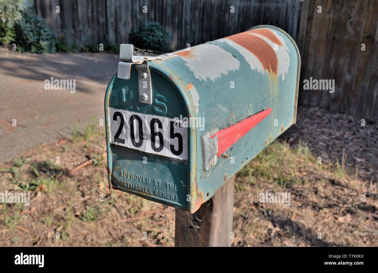 Rusting US Mailbox with number on it on rural route in US America USA Postal Service Stock Photo