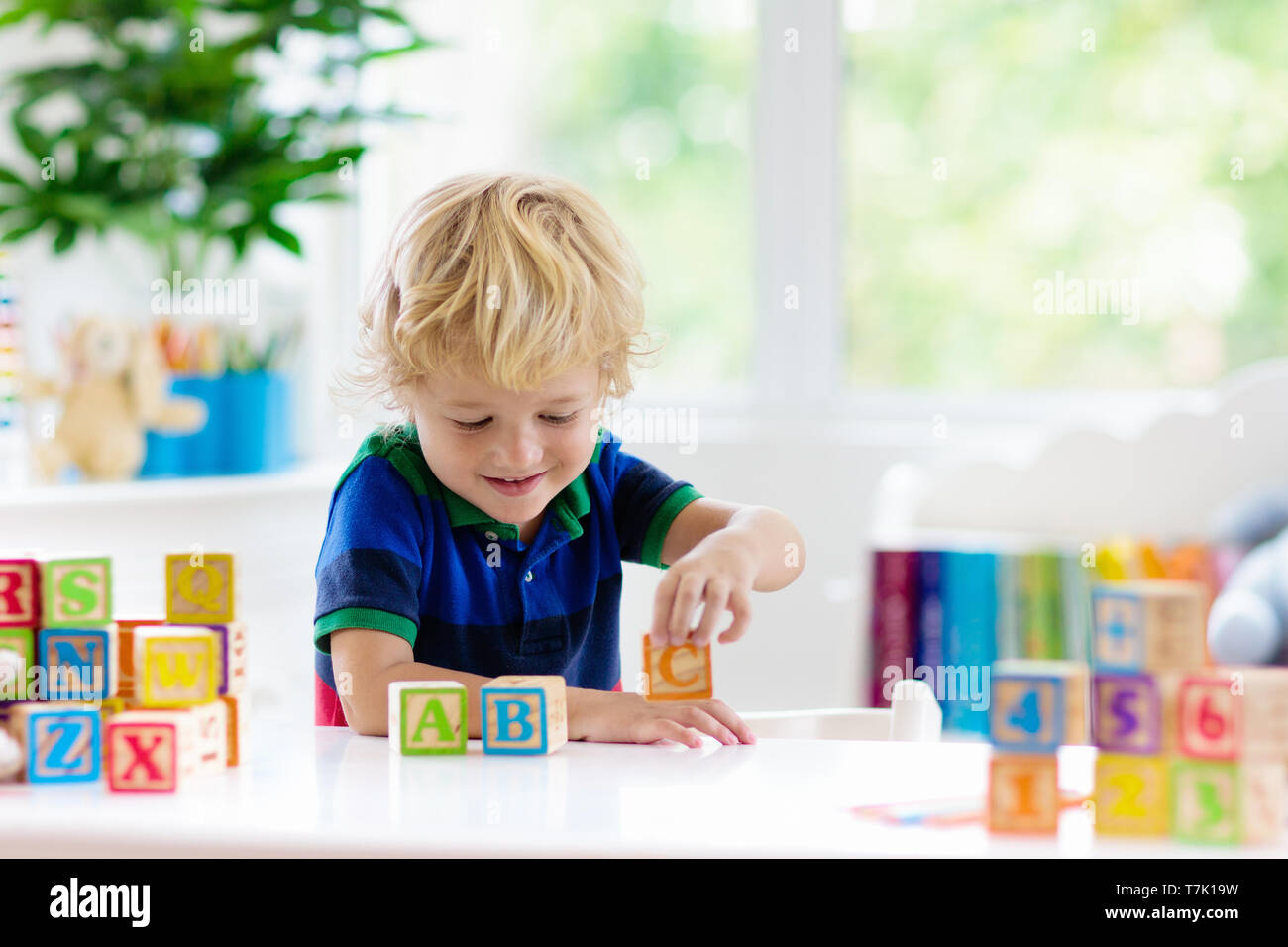Child learning letters and numbers. Kid with colorful wooden abc ...