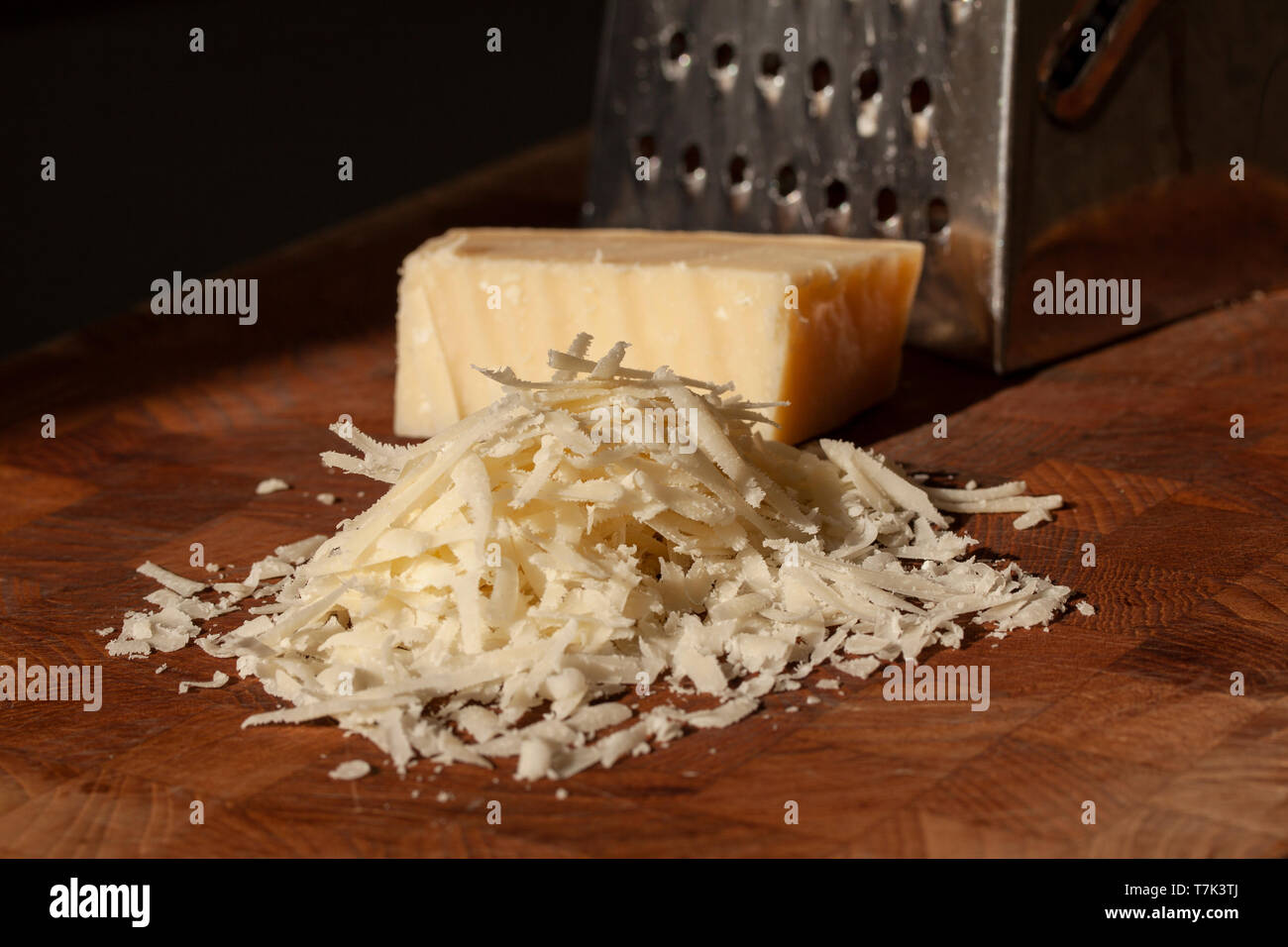 Italian hard cheese with grater on wooden background Stock Photo - Alamy