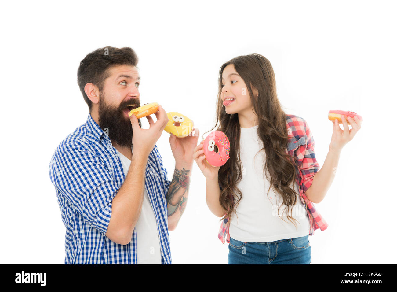 Perfect for dads with sweet tooth. Girl child and dad hold colorful glazed donuts. Sweets and treats concept. Daughter and father eat sweet donuts. Sweet dessert. We love donuts. Fathers day present. Stock Photo