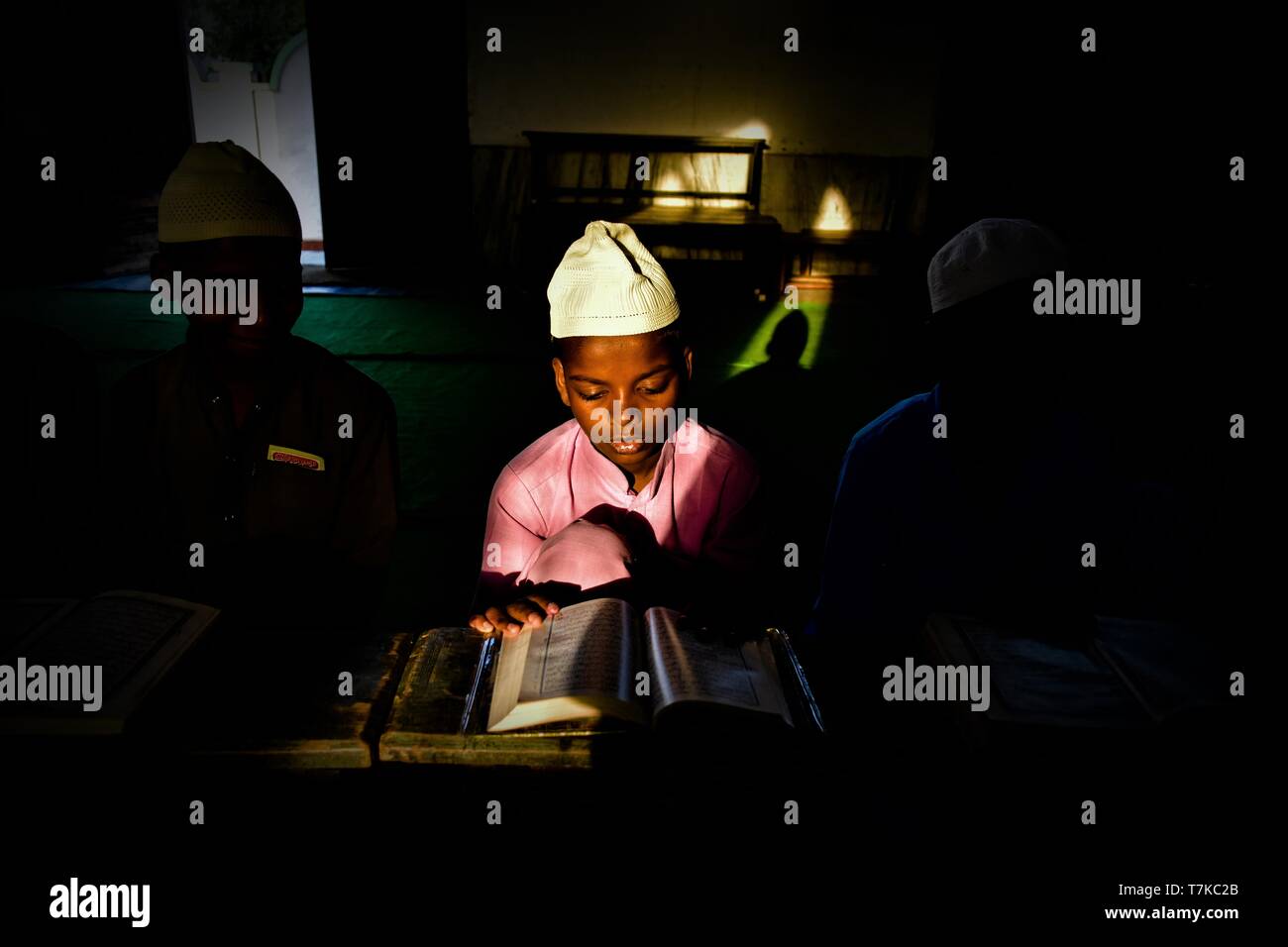 An Indian Muslim boy seen reciting the holy Quran in a mosque during the first day of the holy fasting month of Ramadan in Patiala district of Punjab. Muslims throughout the world are marking the month of Ramadan, the holiest month in the Islamic calendar in which devotees fast from dawn till dusk. Stock Photo