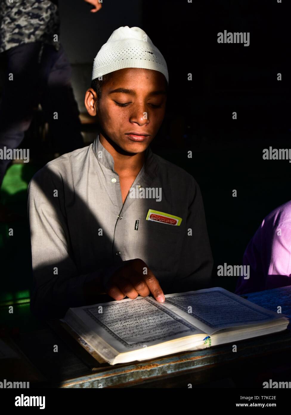 An Indian Muslim boy seen reciting the holy Quran in a mosque during the first day of the holy fasting month of Ramadan in Patiala district of Punjab. Muslims throughout the world are marking the month of Ramadan, the holiest month in the Islamic calendar in which devotees fast from dawn till dusk. Stock Photo