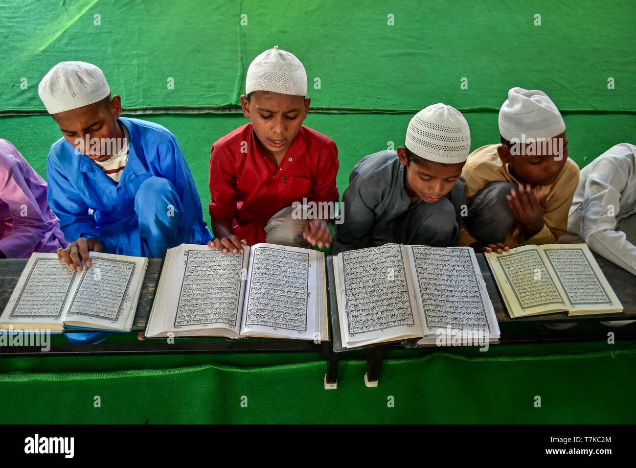 Indian children are seen reciting the holy Quran in a mosque during the first day of the holy fasting month of Ramadan in Patiala district of Punjab. Muslims throughout the world are marking the month of Ramadan, the holiest month in the Islamic calendar in which devotees fast from dawn till dusk. Stock Photo