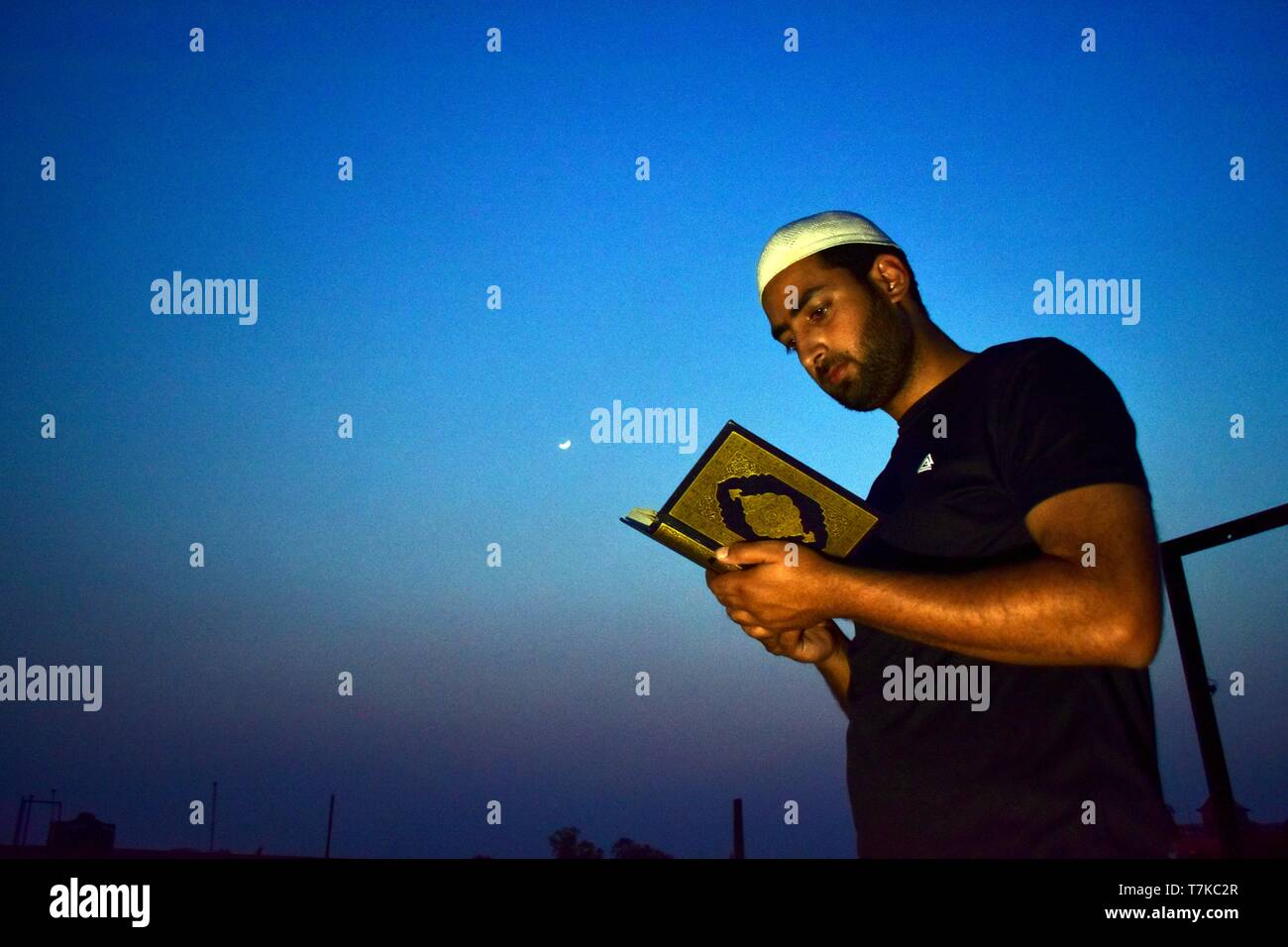 A man seen reciting the holy Quran during the first day of the holy fasting month of Ramadan in Patiala. Muslims throughout the world are marking the month of Ramadan, the holiest month in the Islamic calendar in which devotees fast from dawn till dusk. Stock Photo