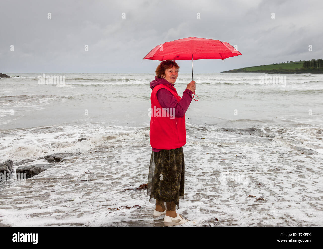 Fountainstown, Cork, Ireland. 08th May, 2019. Brigita De Coppet from Latvia who is visiting her son , gets caught out by  the incoming tide on a rainy day in Fountainstown, Co. Cork, Ireland. Credit: David Creedon/Alamy Live News Stock Photo