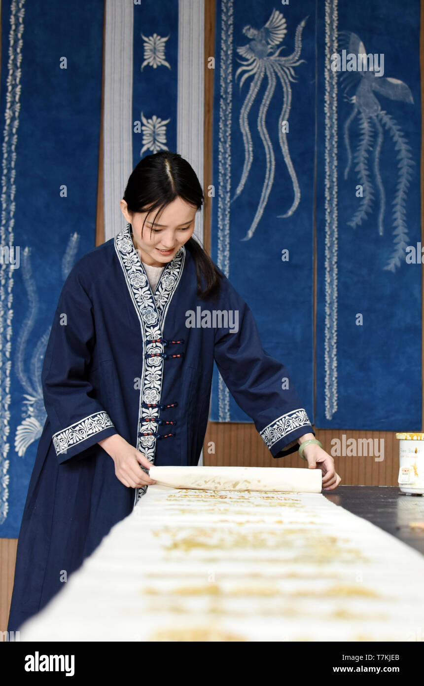 (190508) -- GUIYANG, May 8, 2019 (Xinhua) -- Ran Guangjin arranges the semifinished Fengxiang batik craftwork at her workshop in Duyun City, southwest China's Guizhou Province, May 6, 2019. Ran Guangjin, a former art teacher, now becomes a craftswoman who runs a workshop making Fengxiang batik in southwest China's Guizhou Province. Ran has designed a great variety of Fengxiang printing and dyeing products such as stylish and practical batik clothing and handbags. Fengxiang batik is a kind of wax painting process originated from the Miao-Bouyei Autonomous County of Huishui. Fengx Stock Photo