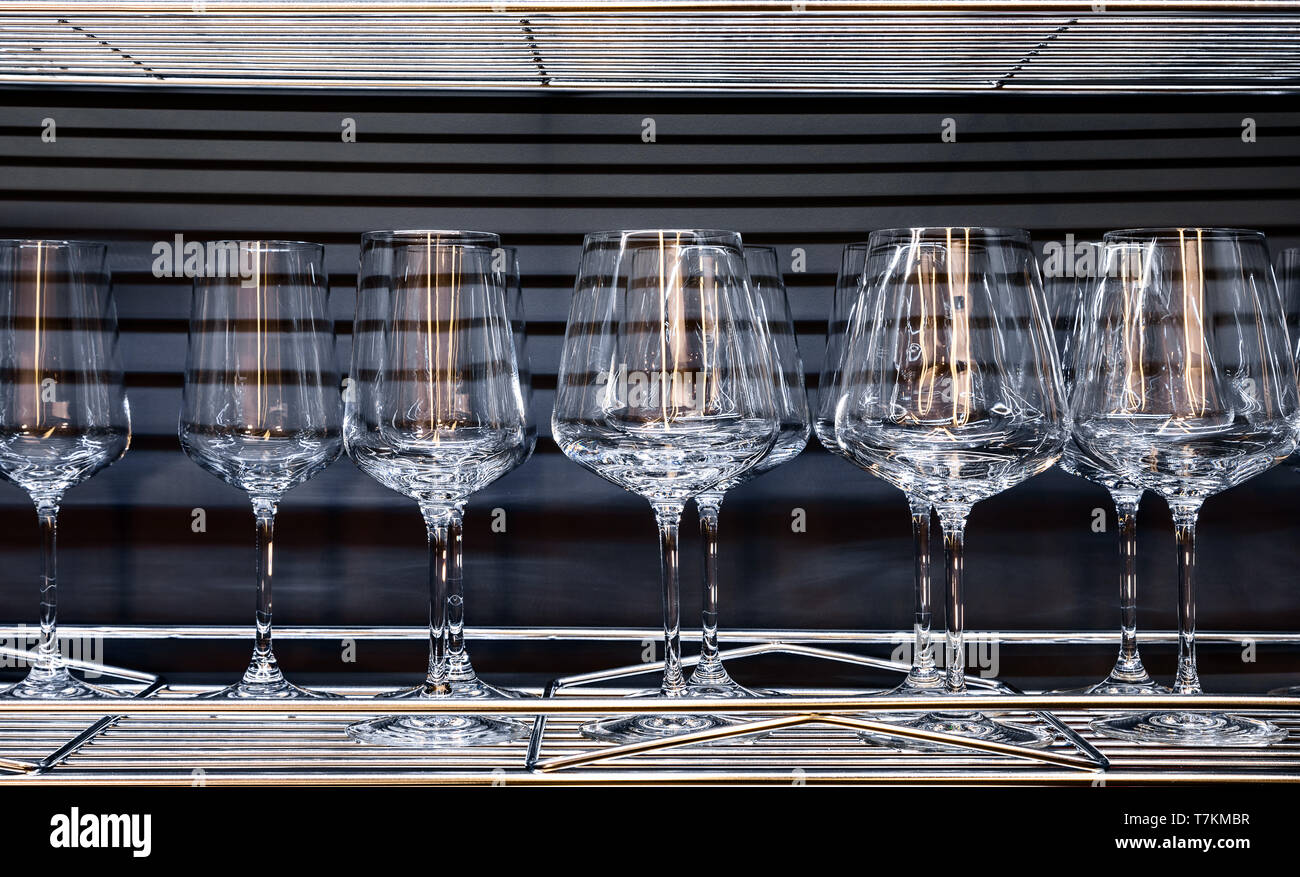 Brandy glasses and wineglasses standing on the shelf. Stock Photo