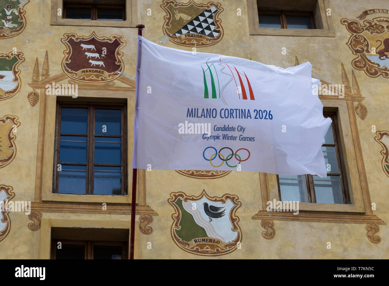 Flag of Milano Cortina candidate city for Olympic Winter Games 2026 on a historic building in Cortina D’Ampezzo, Italy Stock Photo