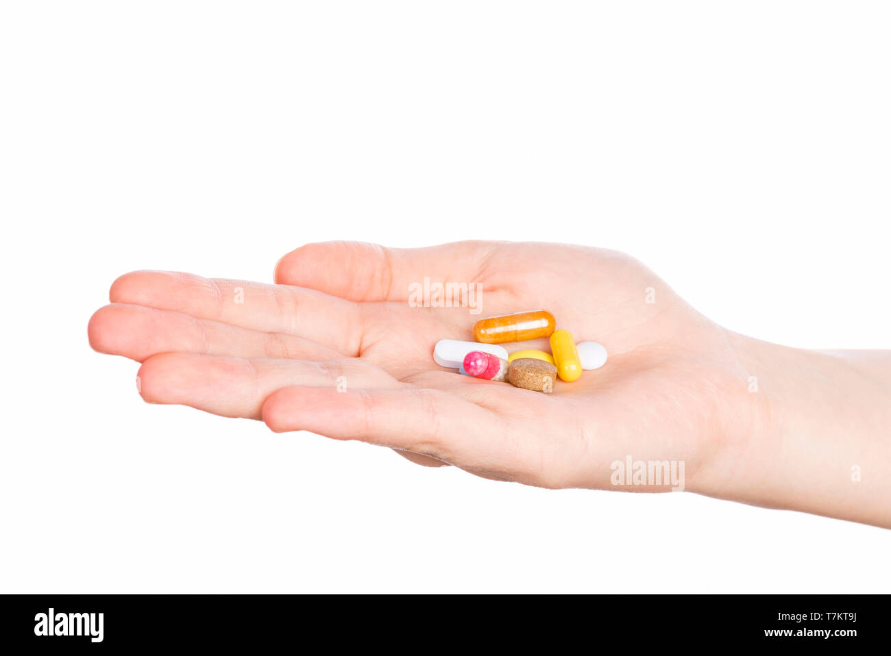 Pills in woman hand isolated on white background. Woman hand holding pills on white Stock Photo