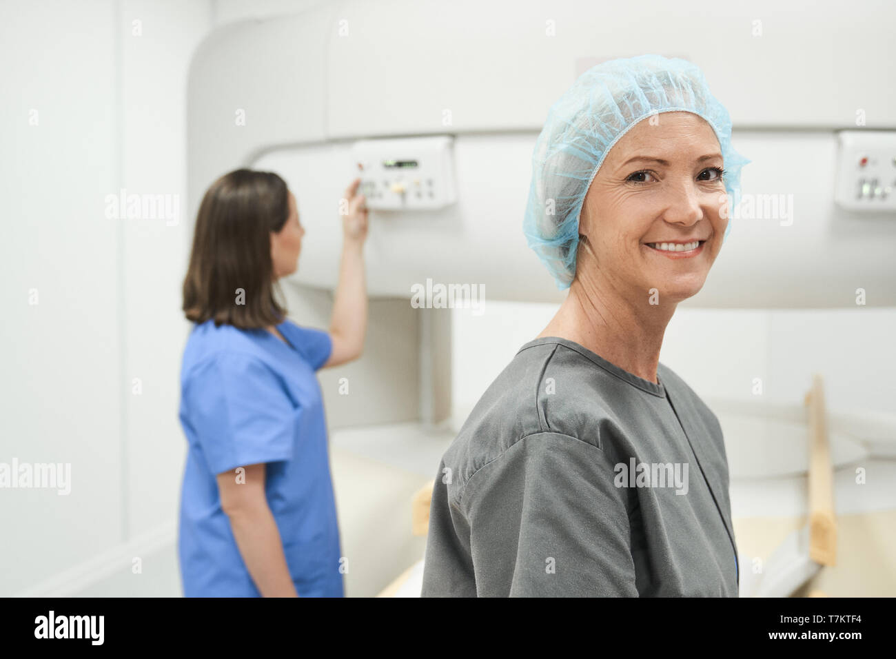 Portrait of happy middle aged patient looking at camera before MRI in hospital lab. Woman smiling in clinic before medical treatment. Stock Photo