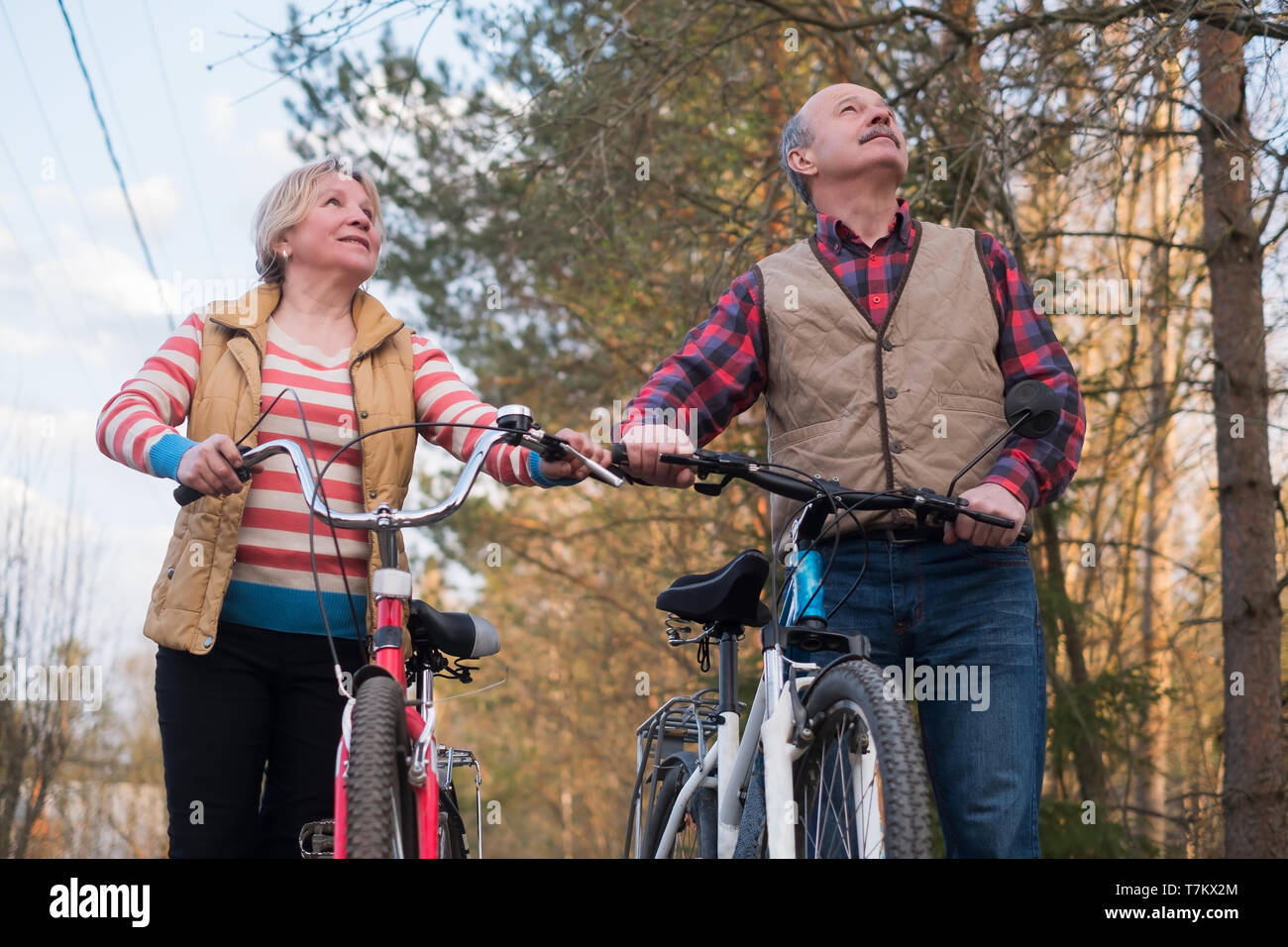 Happy elderly senior couple cycling in park Stock Photo