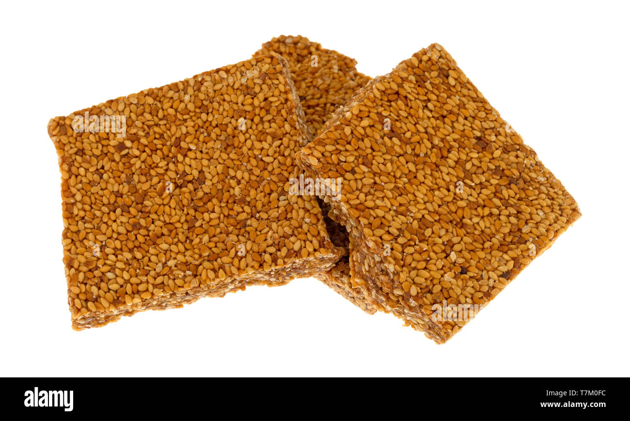 Three pieces of sesame seed crunch candy isolated on a white background