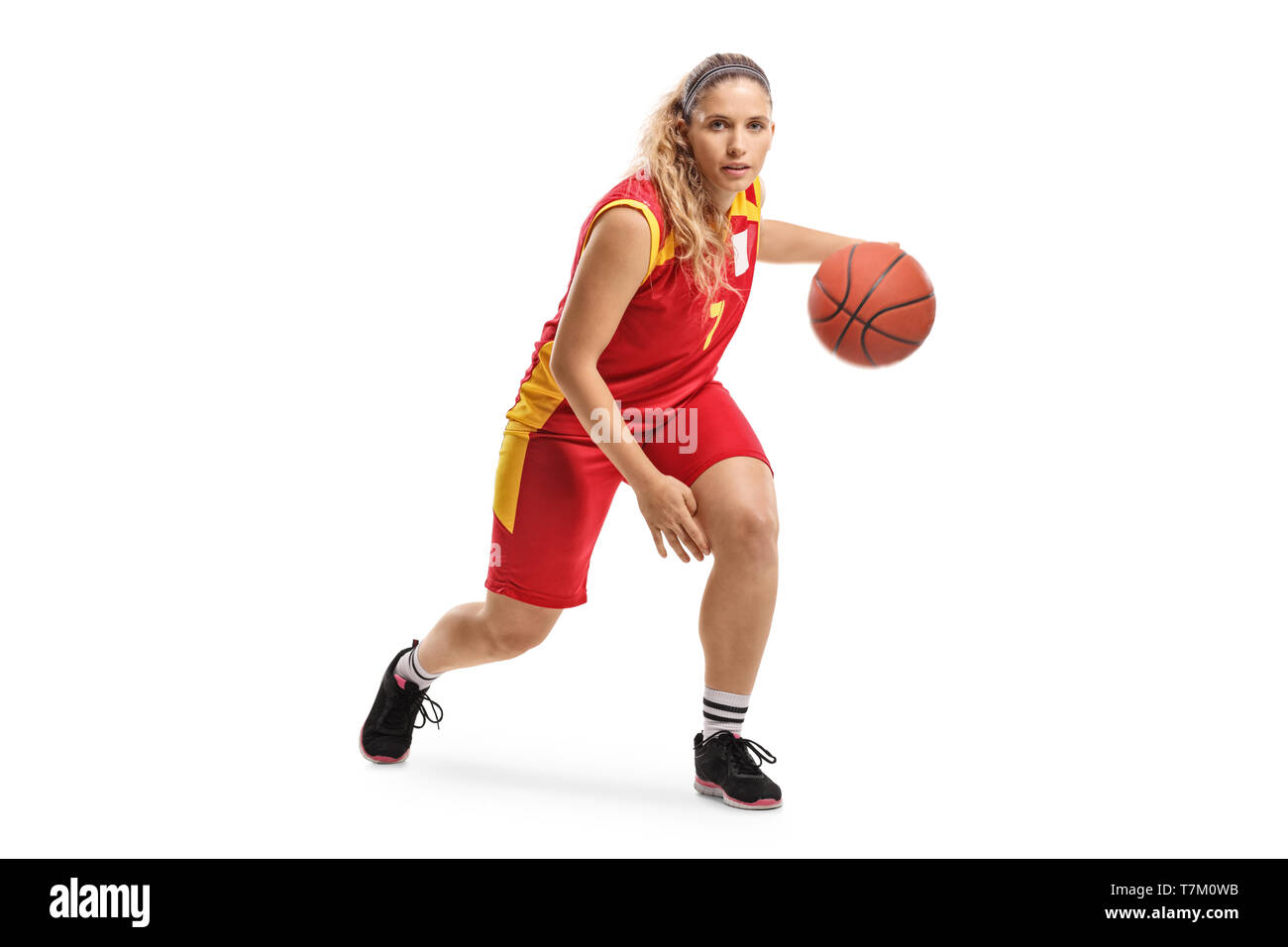 Full length portrait of a female basketball player leading a ball