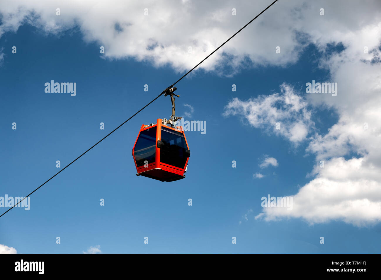 Single red cable car on cableway isolated on blue sky, overhead cableway car of Pohorska vzpenjaca in Maribor, Slovenia Stock Photo
